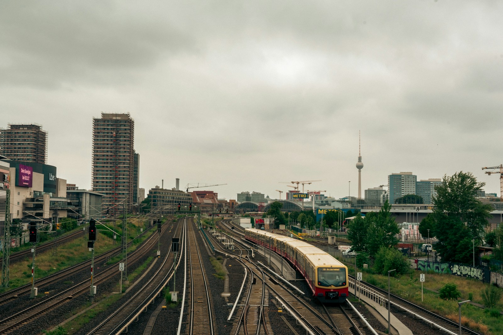 Train traveling through a city with an overcast sky.